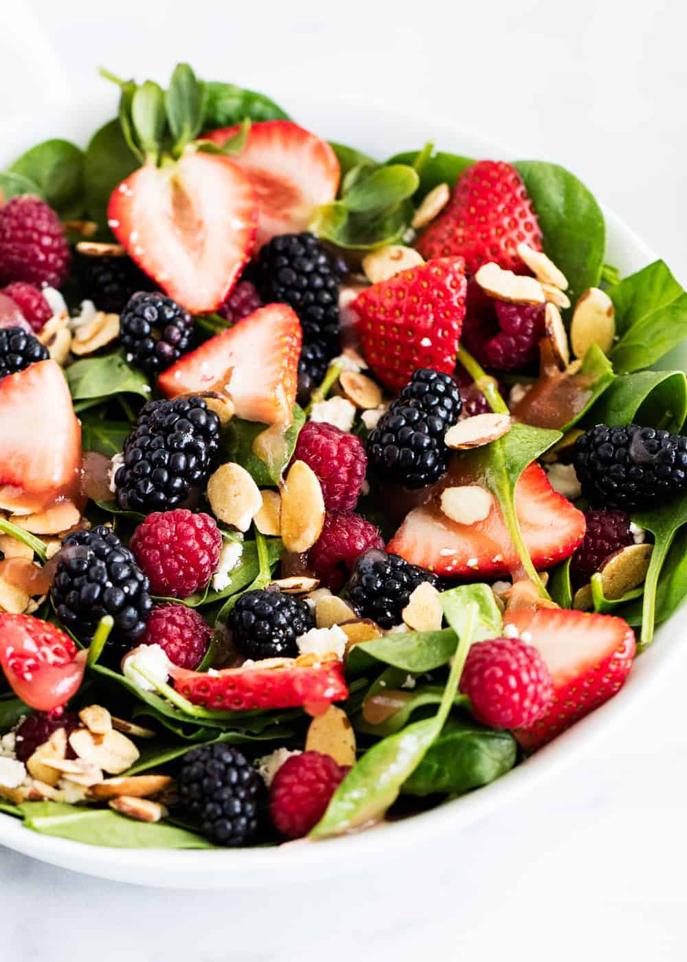 Spinach salad with fresh berries and sliced almonds.