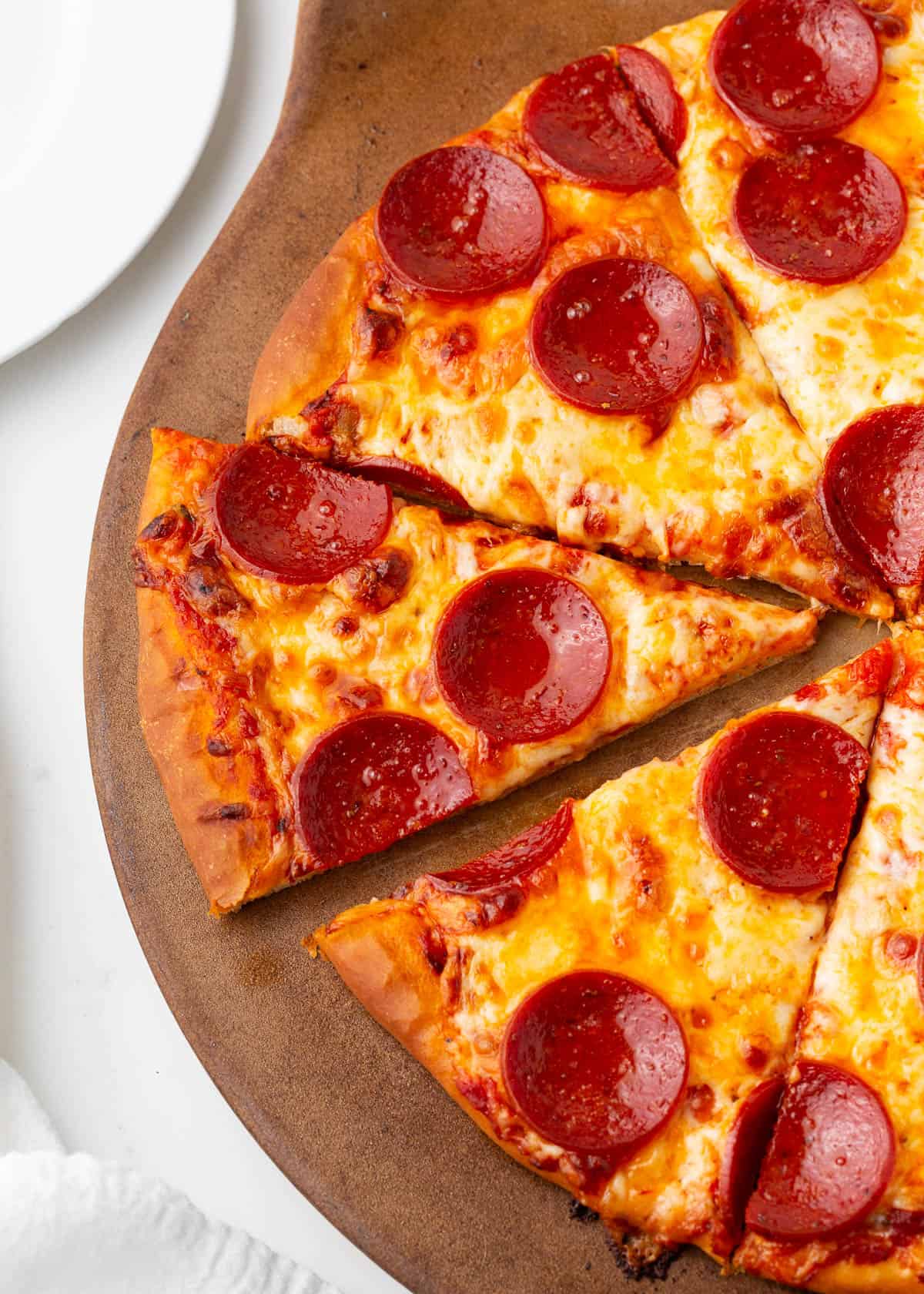 Pizza baked on a pizza stone.