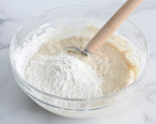 mixing flour in bowl with dough