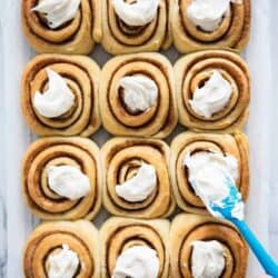 frosting cinnamon rolls with a spatula