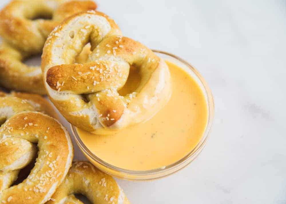pretzel on bowl of cheese dip