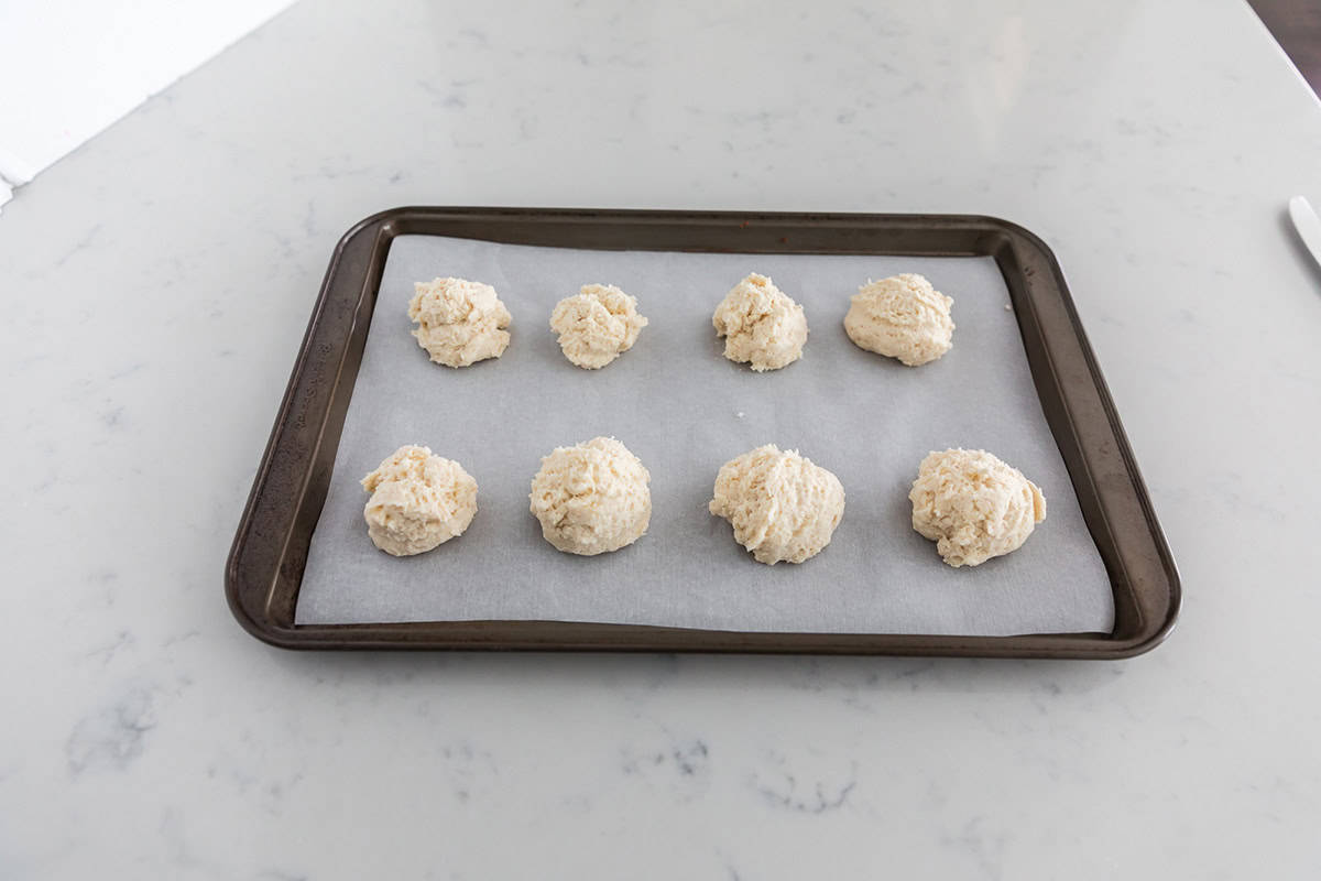 Drop biscuits on parchment paper lined baking sheet.