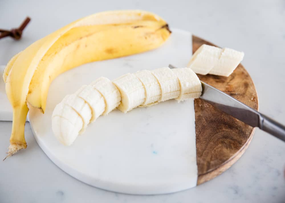 Slicing bananas on cutting board.
