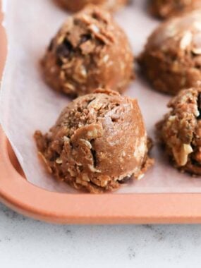 Chocolate peanut butter protein balls on a baking sheet.