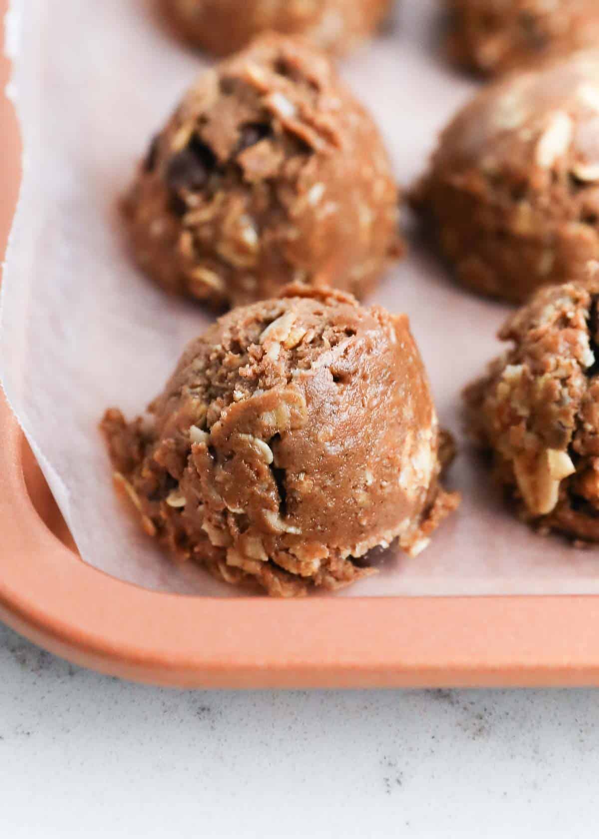 Up close photo of the protein balls on a cookie sheet. 