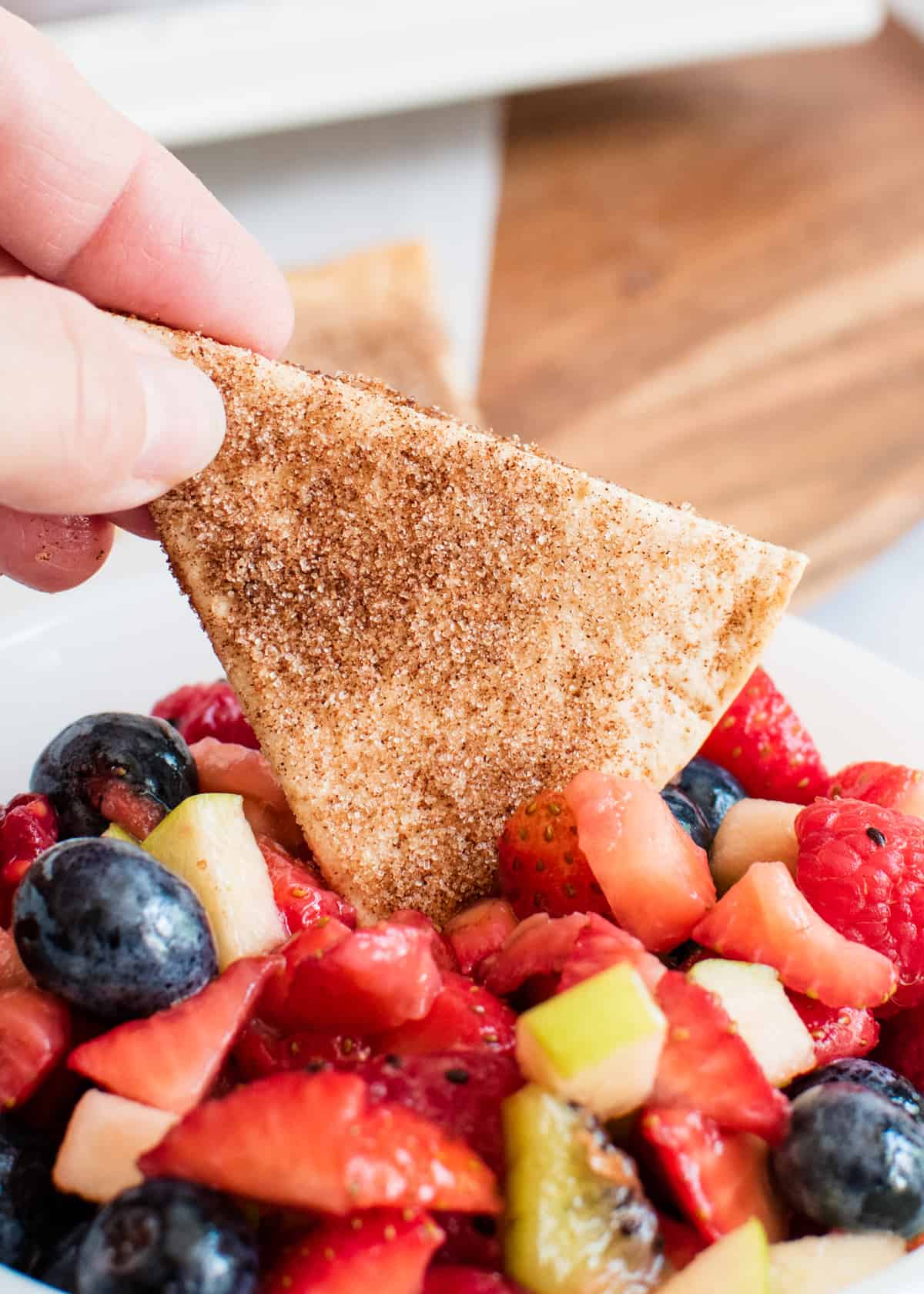 Tortilla chip dipped in fruit salsa.