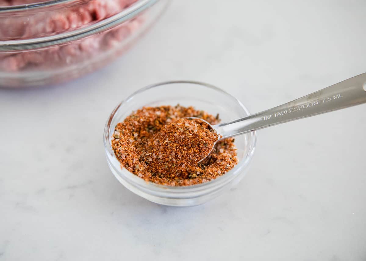 Stirring hamburger seasoning.