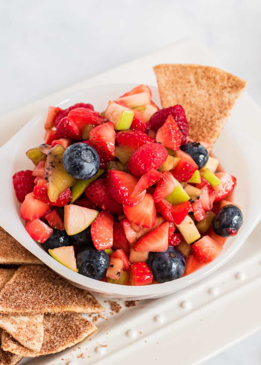 fruit salsa in white bowl with cinnamon chips