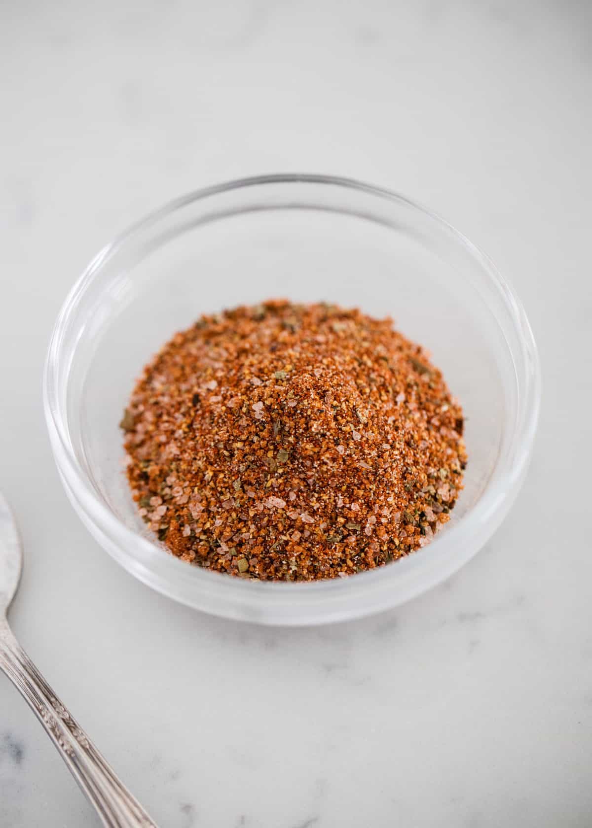 Hamburger seasoning in a glass bowl.