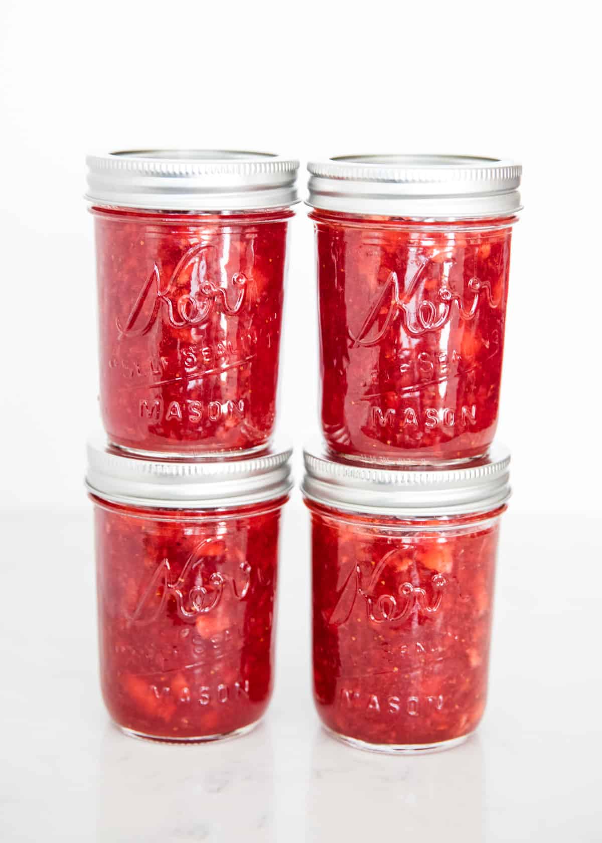 Stacked jars of strawberry jam.