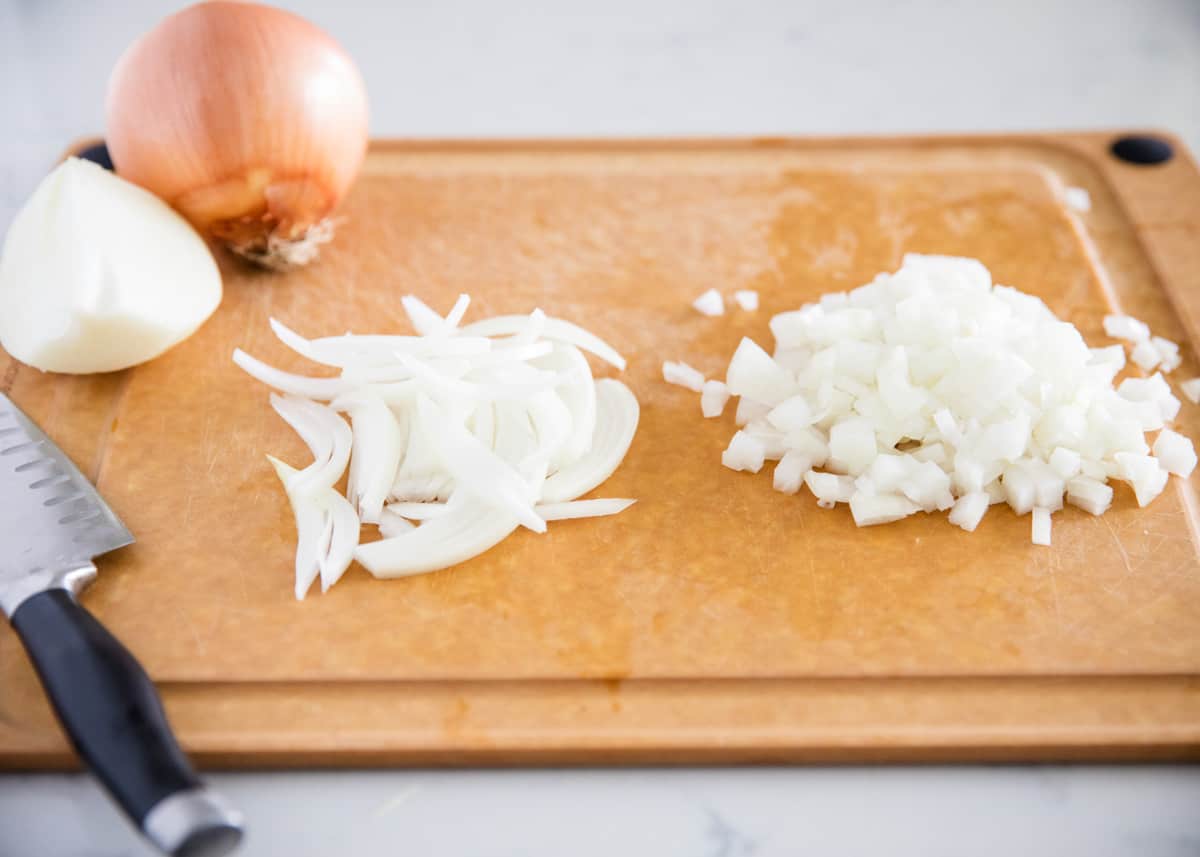 Cutting onions on cutting board.