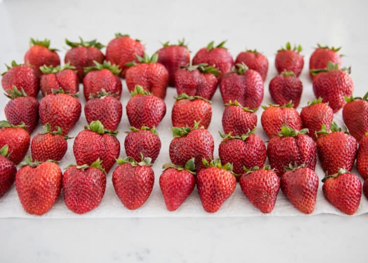 rows of washed strawberries on paper towel 