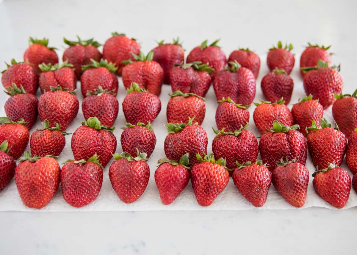 Rows of washed strawberries on paper towel.