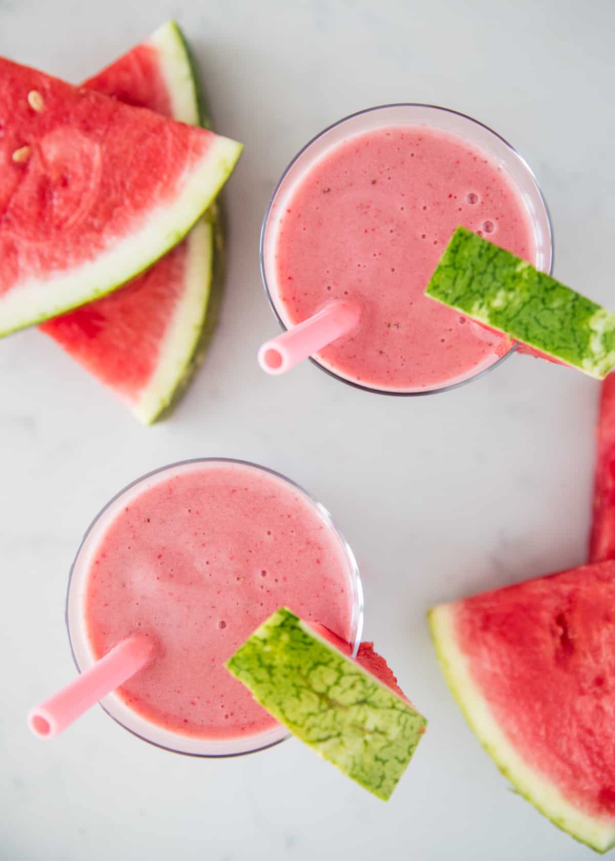 This watermelon smoothie is the perfect drink on a hot summer day! It's cold, creamy, naturally sweet and super refreshing. It has the perfect amount of watermelon flavor. Watermelon smoothie in cups.