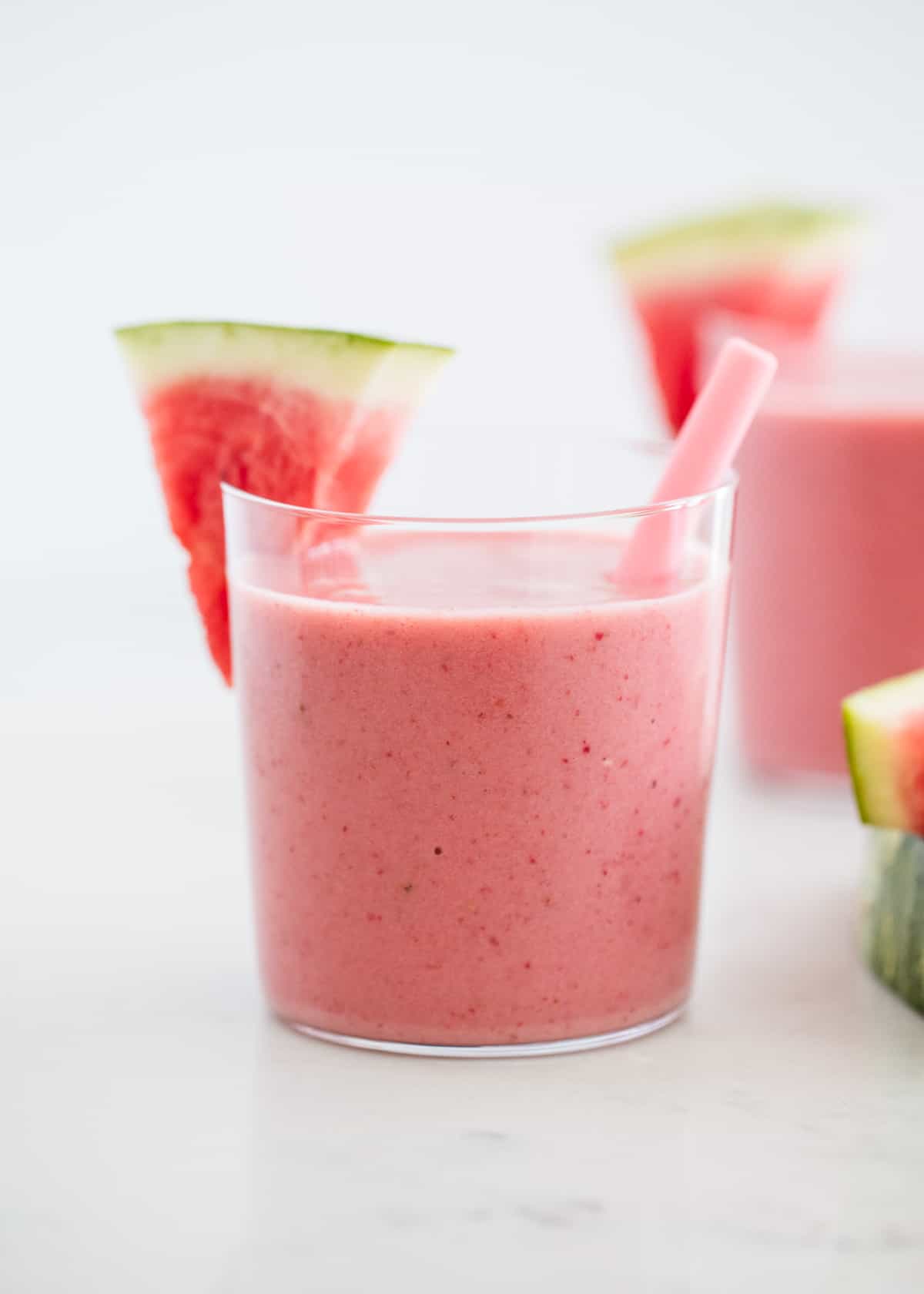 This watermelon smoothie is the perfect drink on a hot summer day! It's cold, creamy, naturally sweet and super refreshing. It has the perfect amount of watermelon flavor. Watermelon smoothie in glass cups.