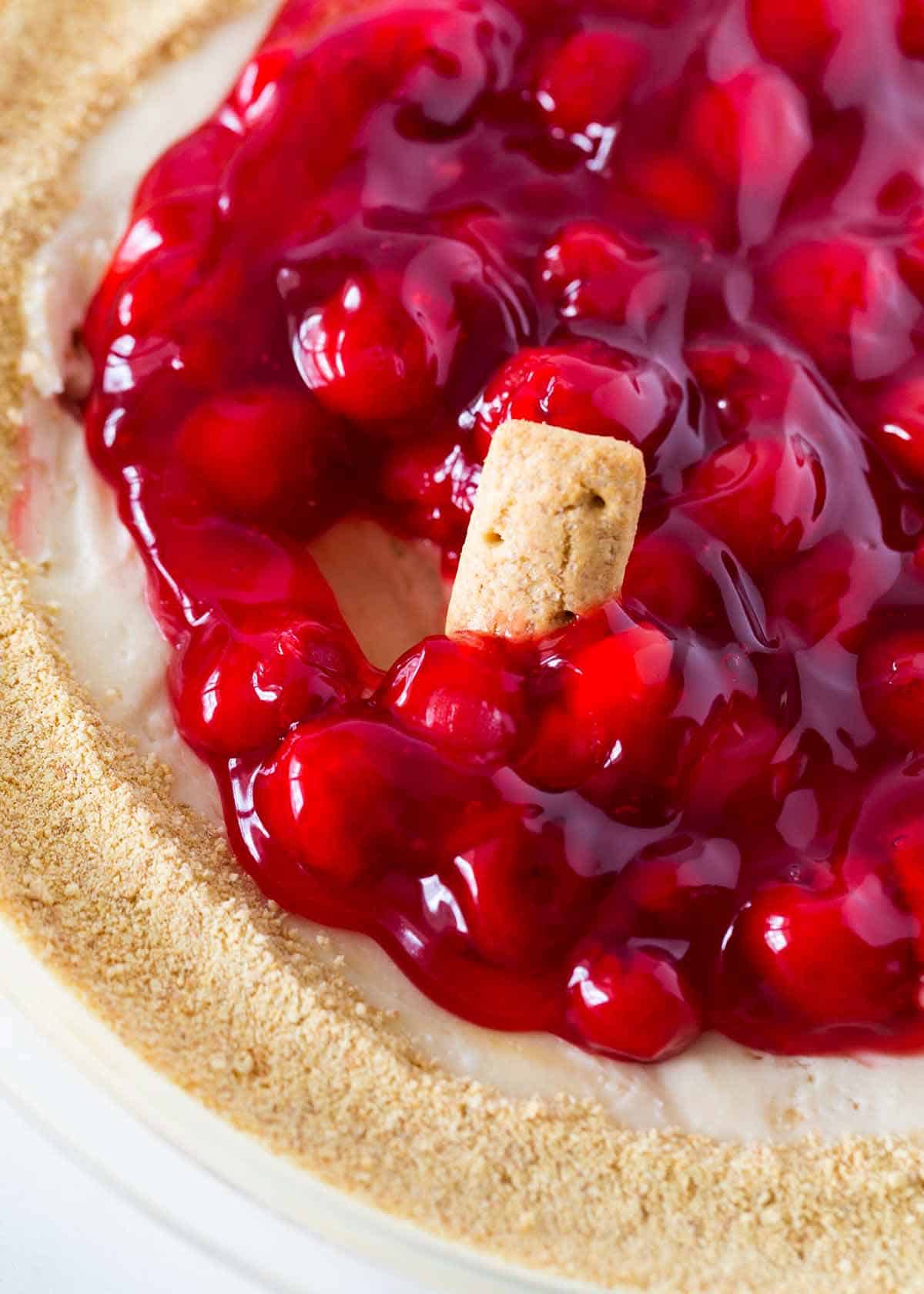 Cherry cheesecake dip in glass pie dish.