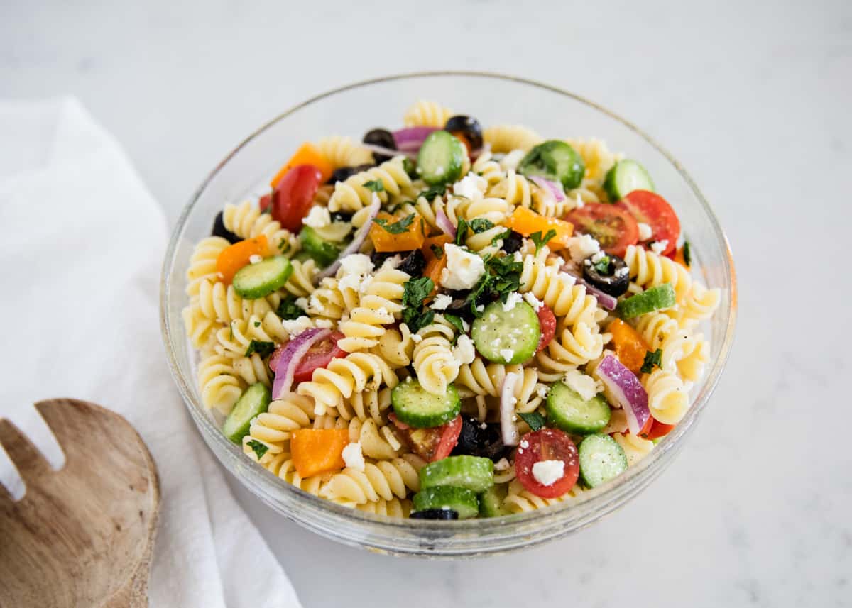 Greek pasta salad in a glass bowl.