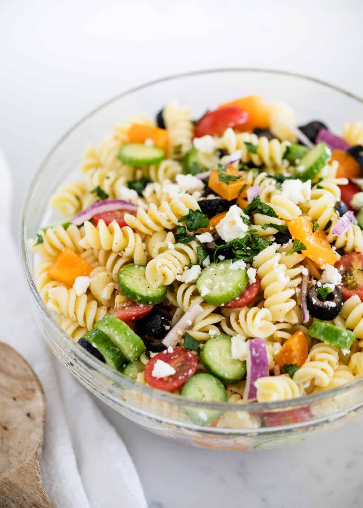 Greek pasta salad in a glass bowl.