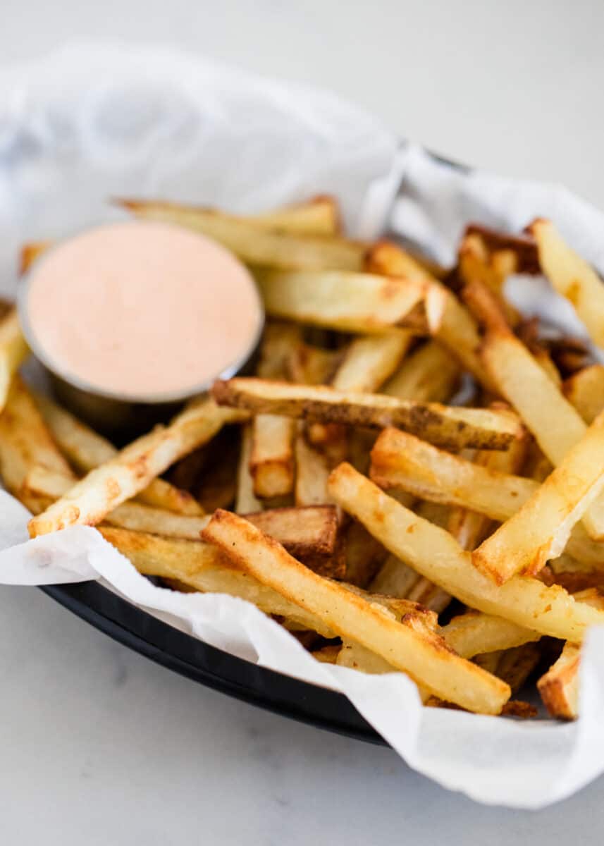 Easy homemade french fries that are tender, crispy and cooked to perfection. Can be made in the oven, air fryer or by deep frying. These french fries taste just like they came from a restaurant! Homemade french fries in a basket.