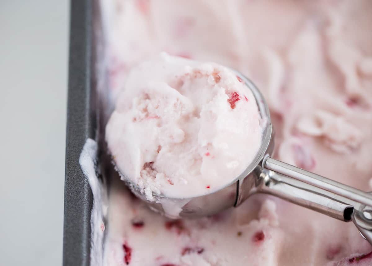 Strawberry ice cream being scooped.
