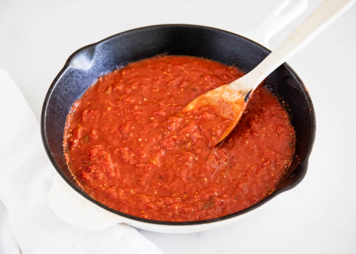 Marinara sauce in skillet with a wooden spoon.