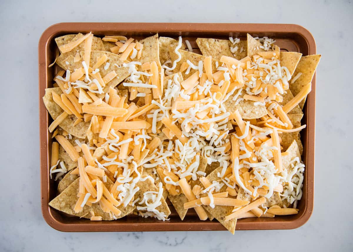 Tortilla chips with cheese on pan.