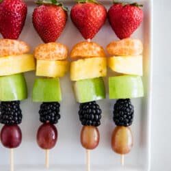 rainbow fruit kabobs on white plate