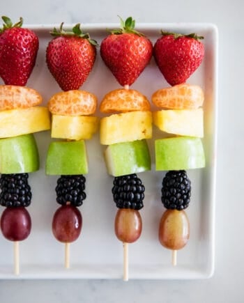 rainbow fruit kabobs on white plate