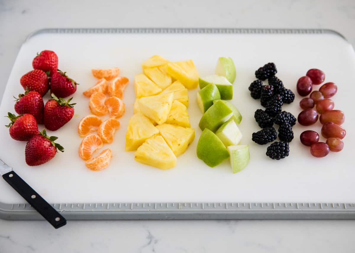 Fruit on white cutting board.