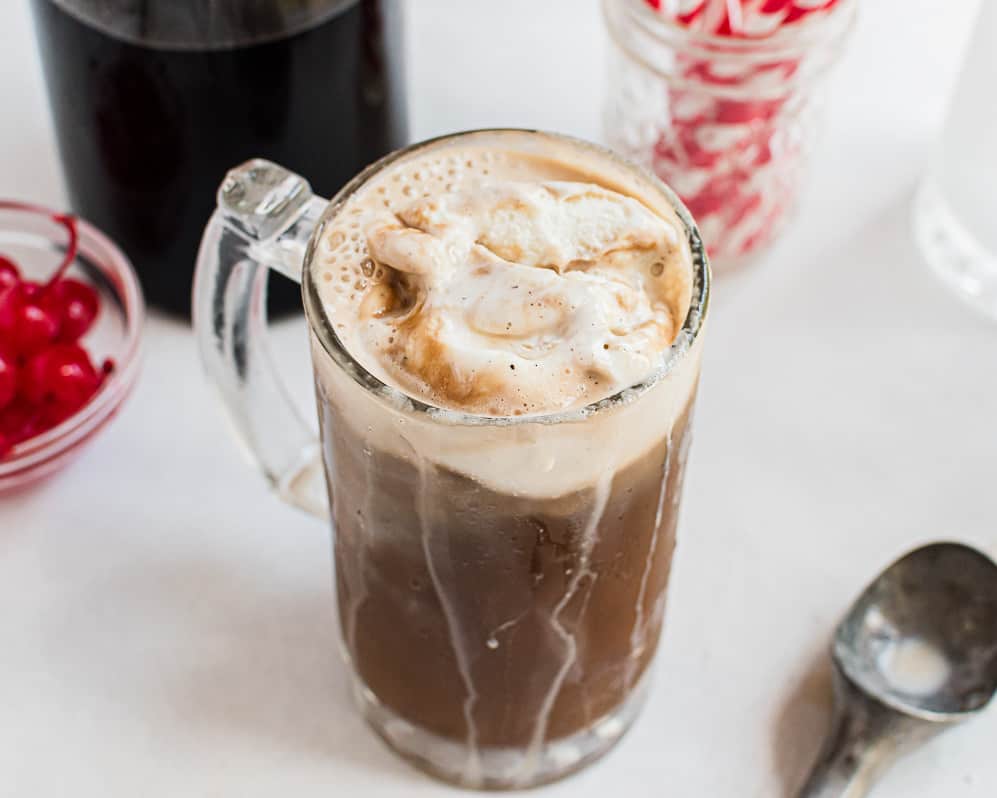 Root beer float with root beer and ice cream in a glass.