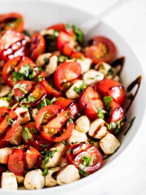 Tomato basil mozzarella salad in white bowl.