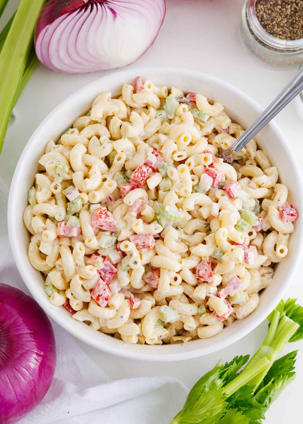 Easy macaroni salad in a white bowl with serving spoon.