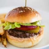 hamburger on white plate with french fries