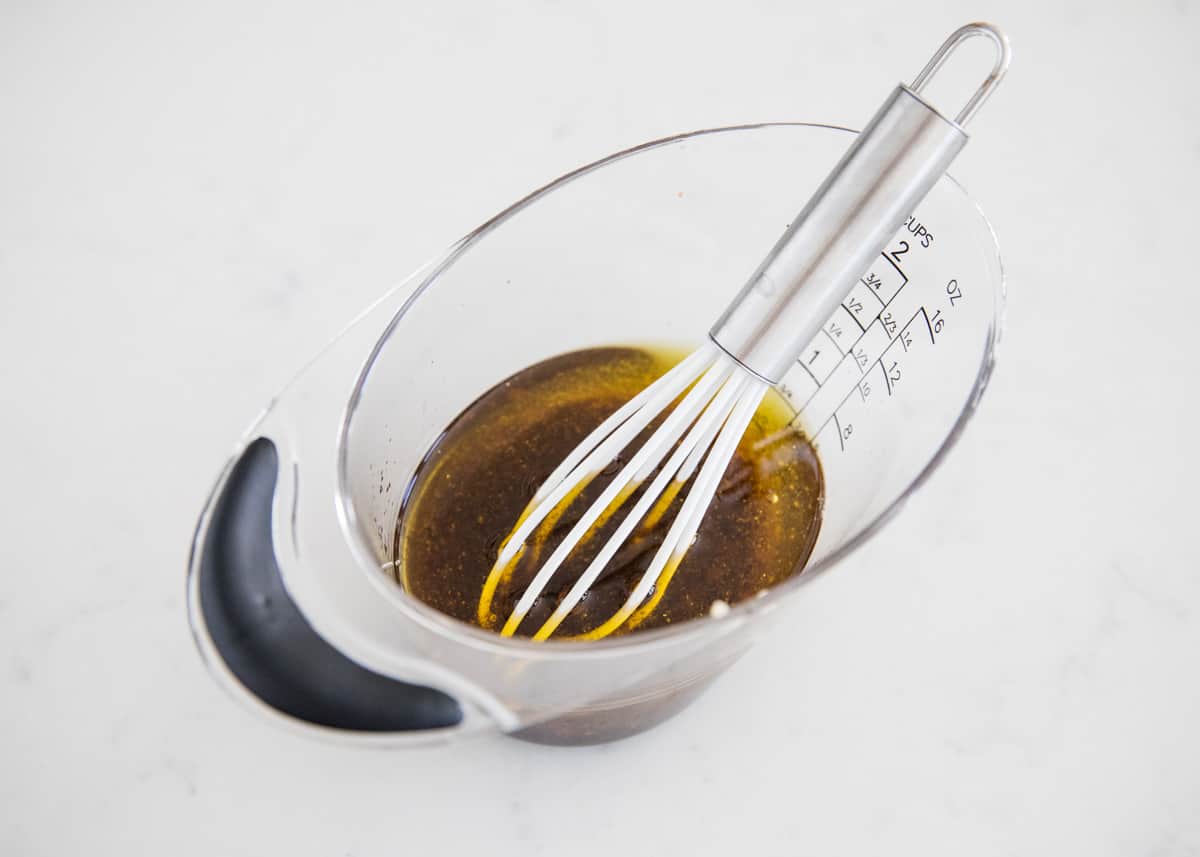 Whisking balsamic dressing in a measuring cup.