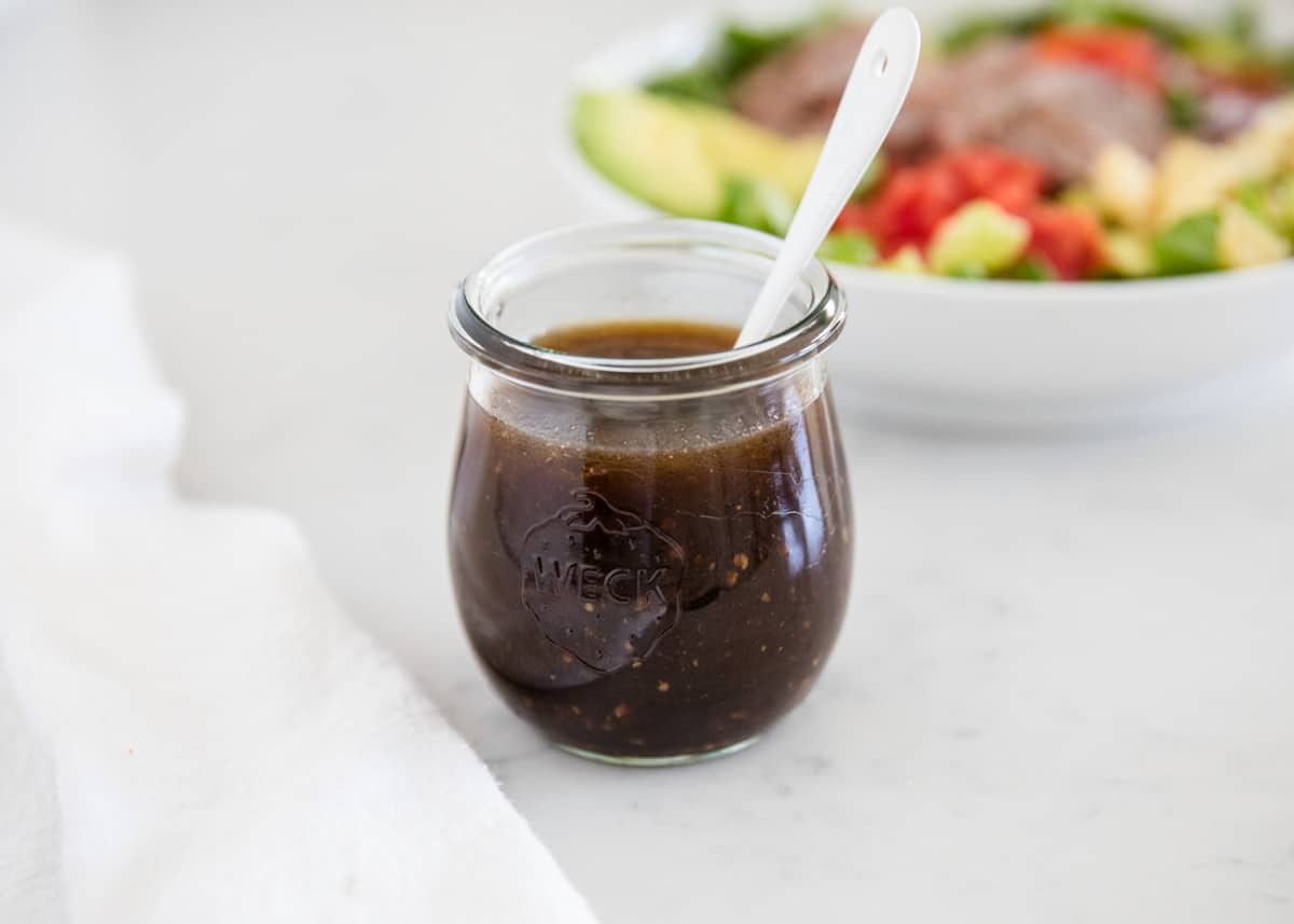 Balsamic dressing in a jar with a spoon.