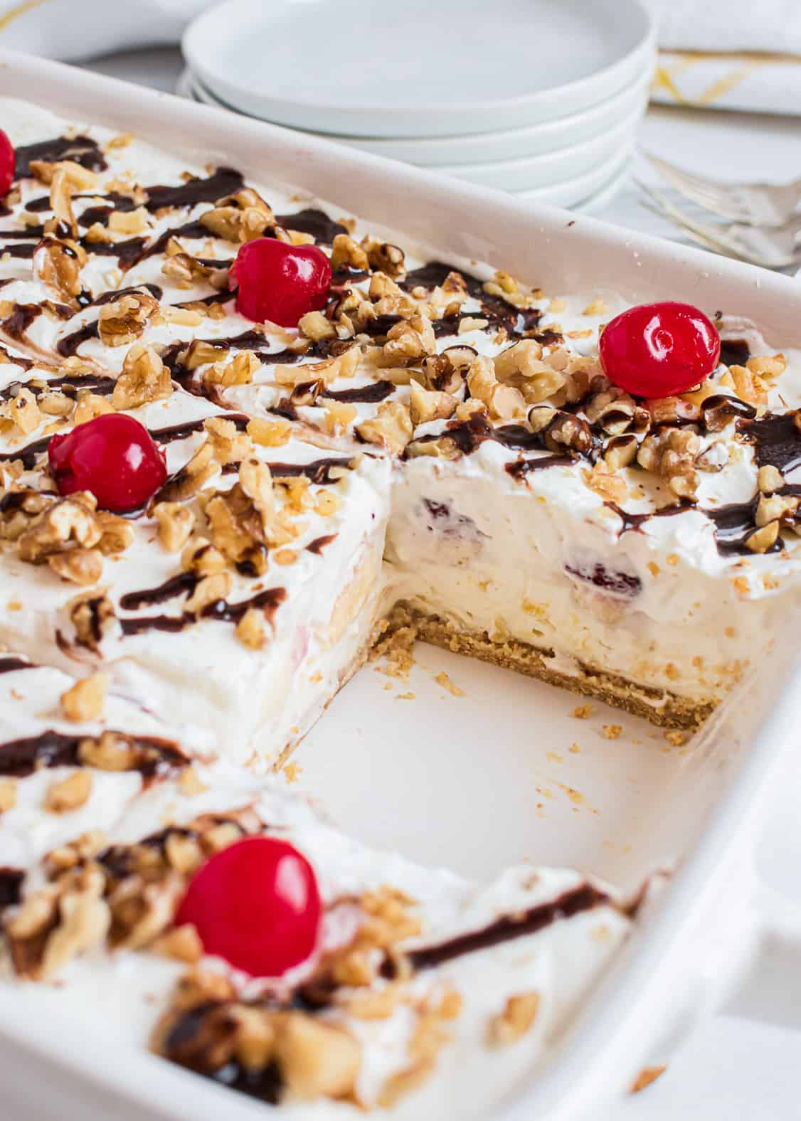 Banana split dessert cake in white cake pan.