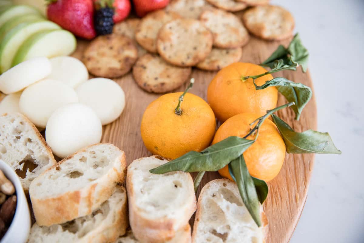 Oranges on a fruit and cheese board.