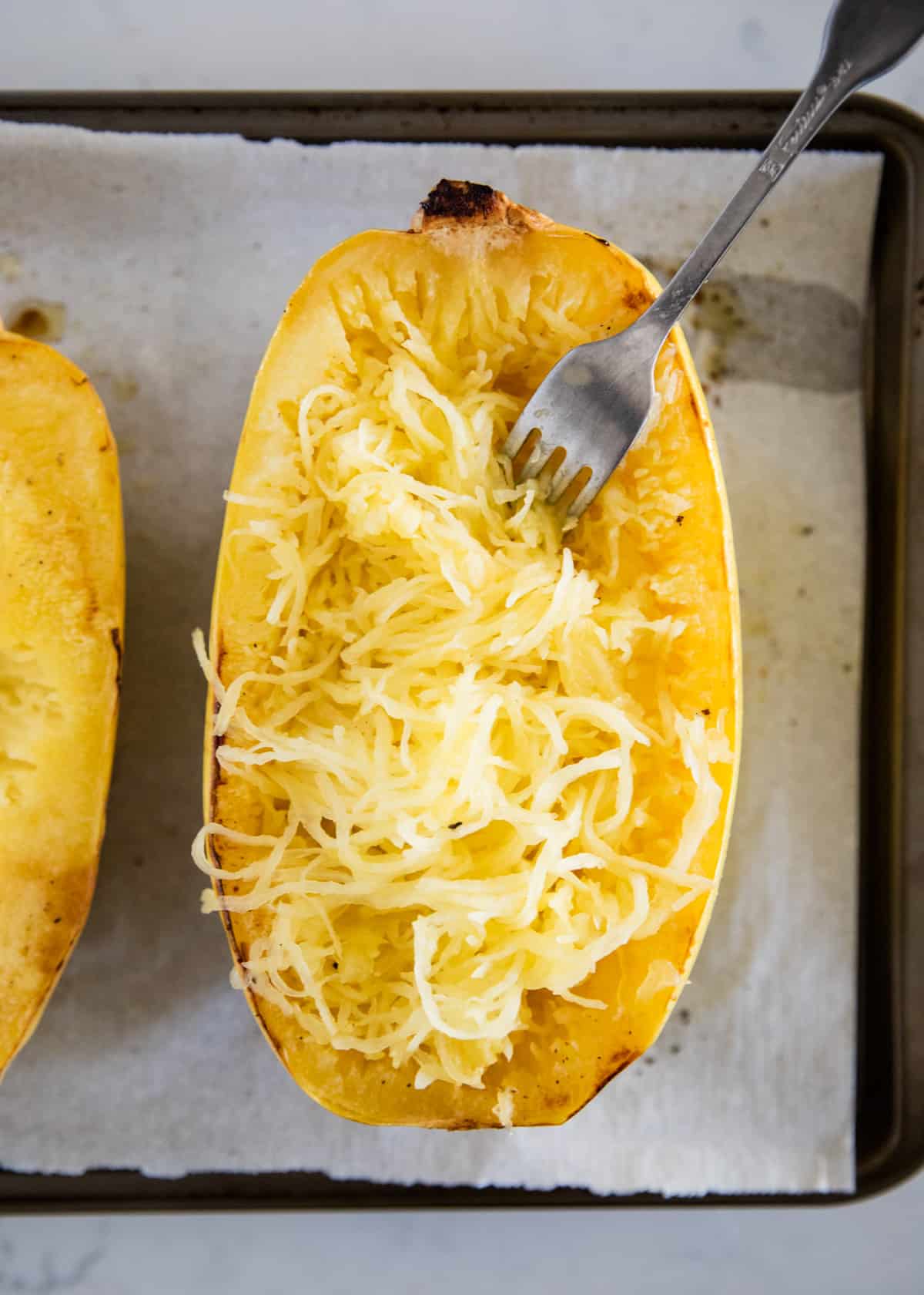 Cooked spaghetti squash on a baking sheet.
