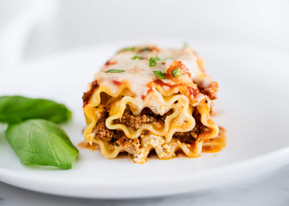 Lasagna roll up on white plate.