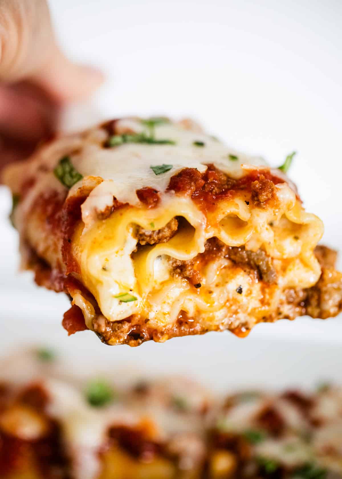 lifting lasagna roll up out of pan