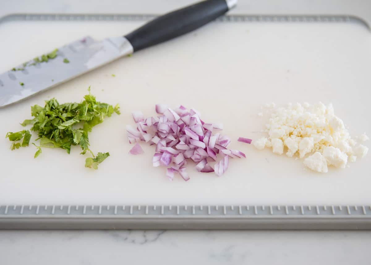 Taco toppings on cutting board.