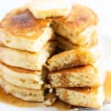 Stack of buttermilk pancakes with a bite taken.