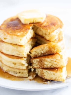 Stack of buttermilk pancakes with a bite taken.