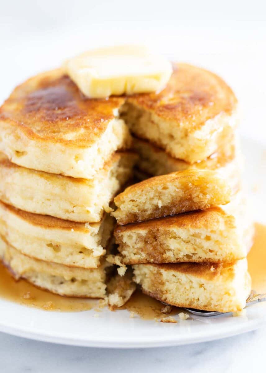 Stack of buttermilk pancakes with a bite taken. 