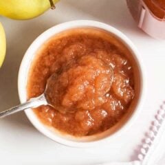 Crockpot applesauce in a white bowl with a spoon.