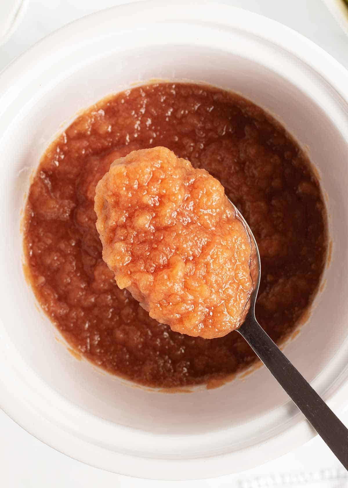 Crockpot applesauce made with only a few ingredients and SO delicious! Once you've made this homemade version, you'll never go back to store-bought. So easy and fresh! Spoonful of blended crockpot applesauce.