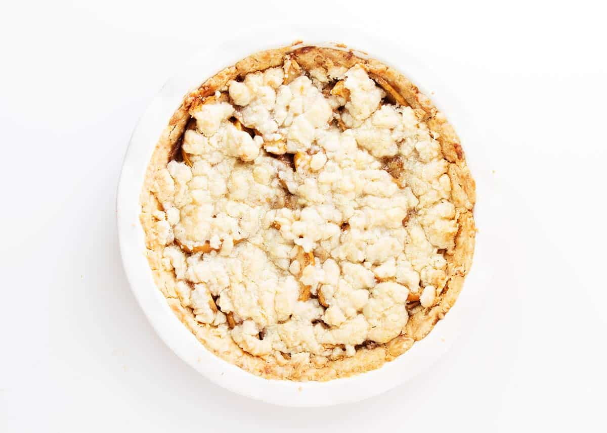 Easy brown bag apple pie with a delicious crumb topping and flaky pie crust. The brown bag helps seal in all of the delicious flavors and leaves you with the best apple pie you've ever tried. Apple pie in dish.