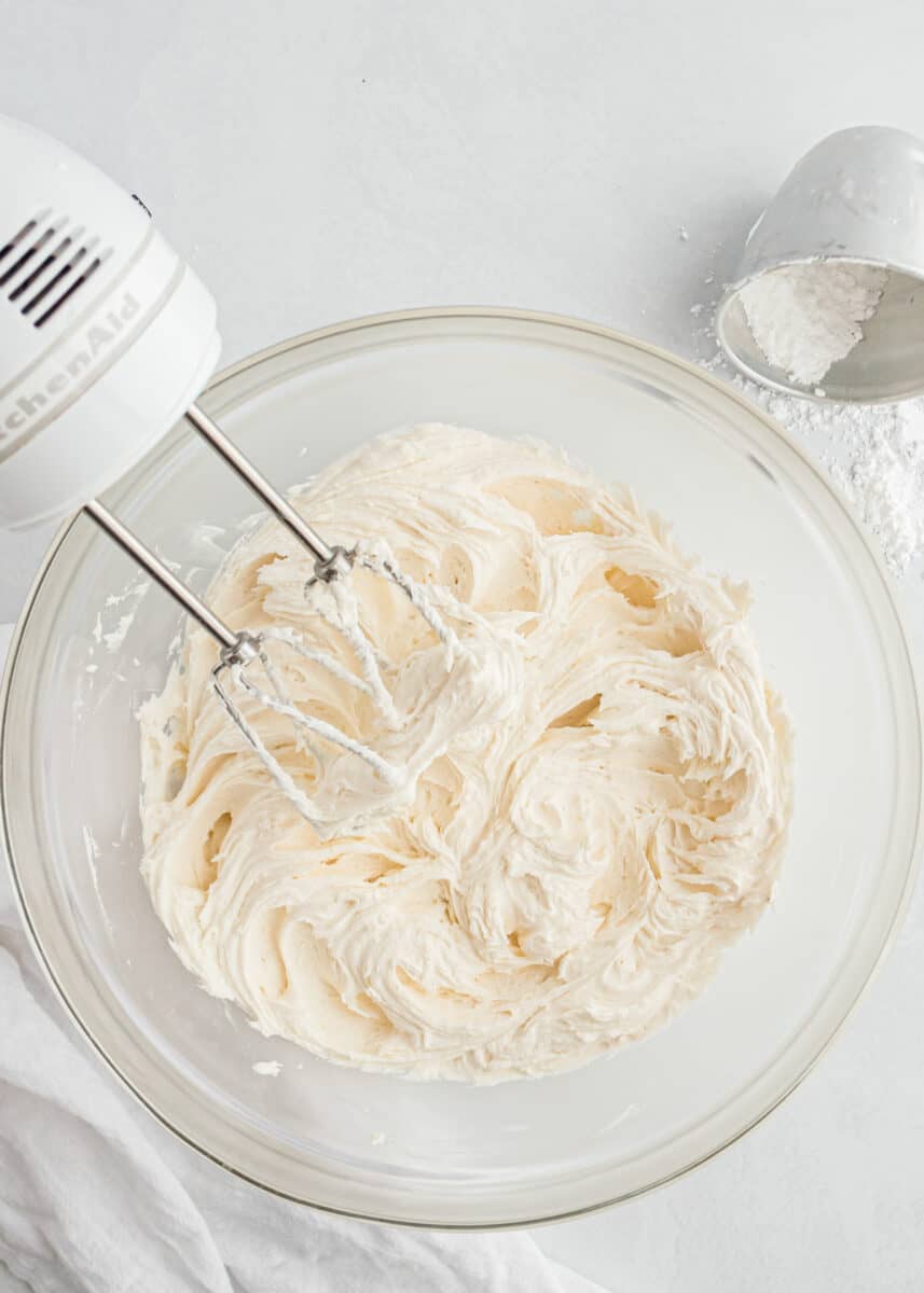 mixing buttercream frosting in glass bowl
