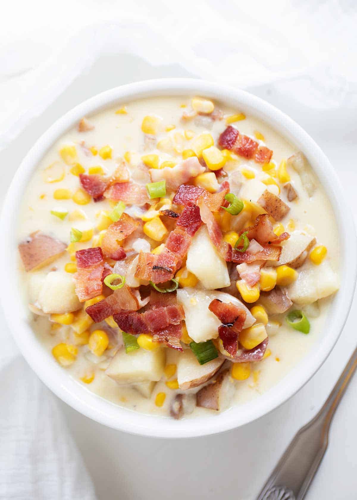 Corn chowder in white bowl.