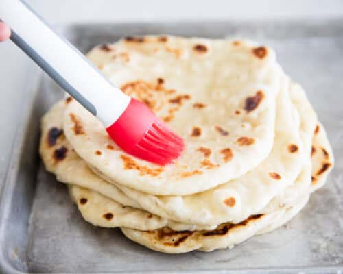 brushing butter on naan bread